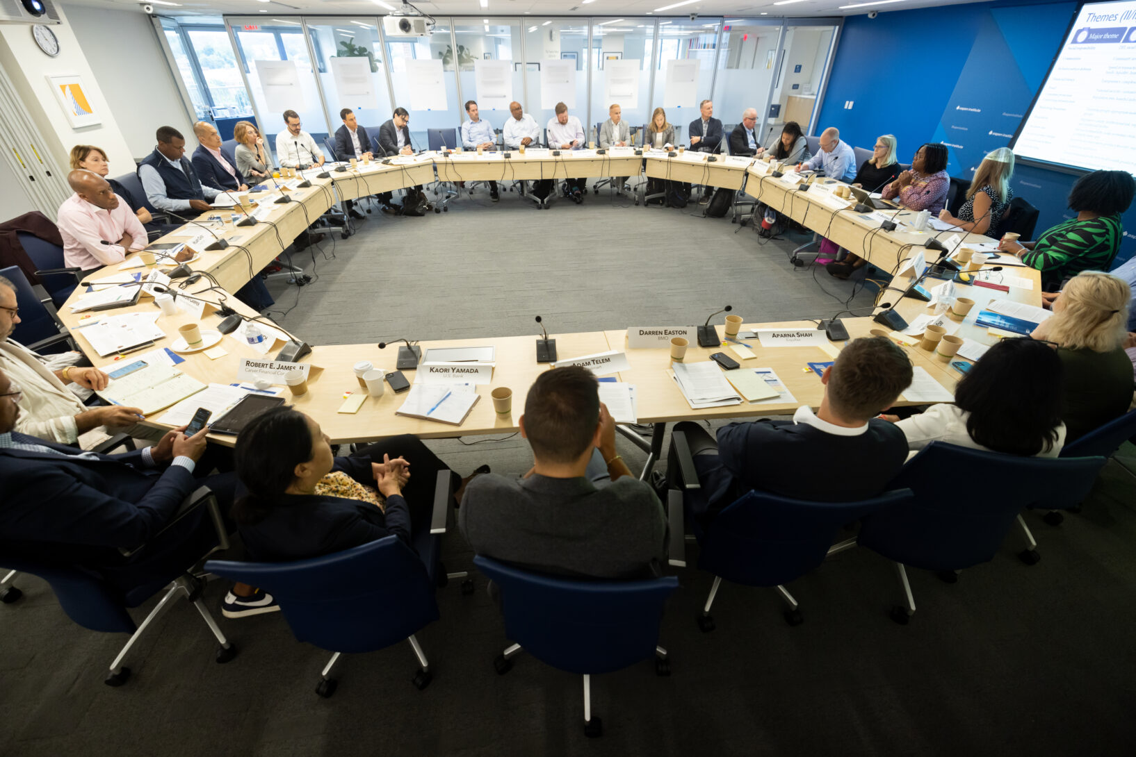 A group of people sit around a round table.