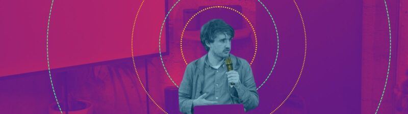 Brandon giving a talk on public AI infrastructure at the event, with psychedelic stylized coloring.