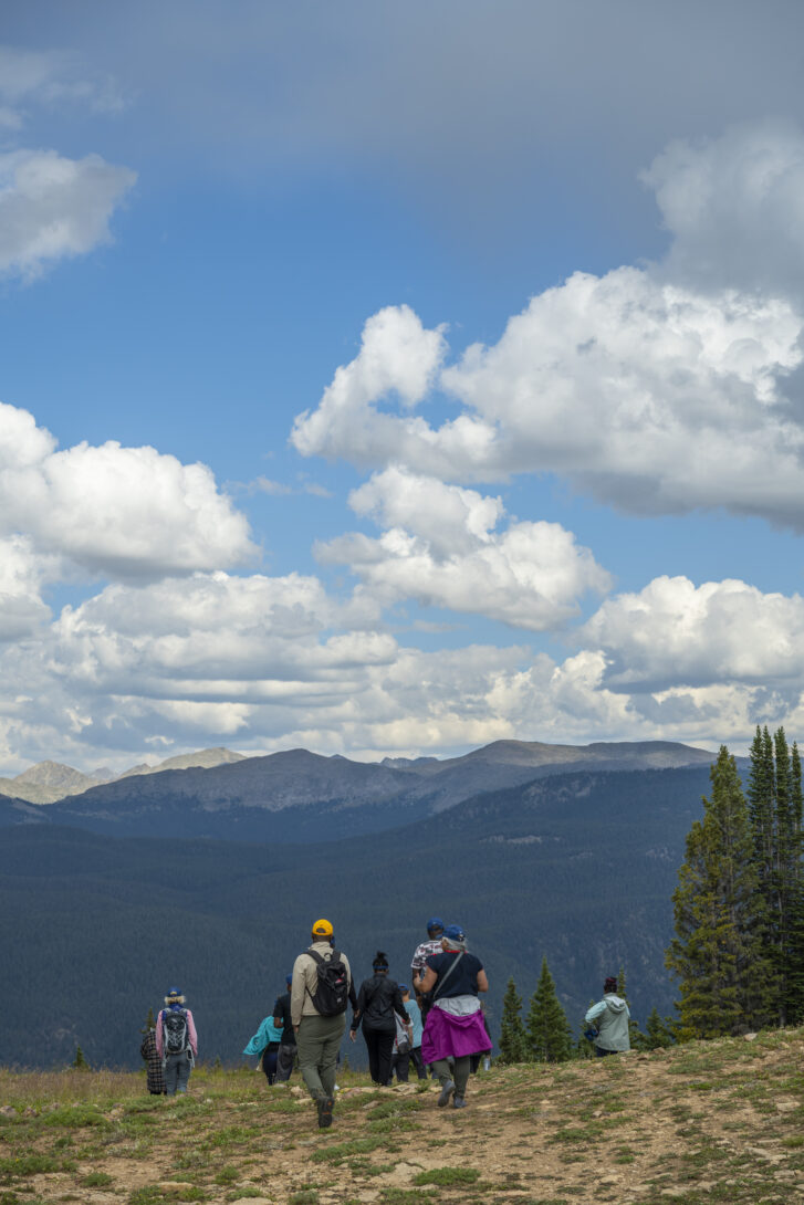 A group of hikers descend a mountain in Aspen, Colorado.