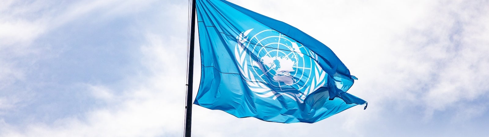 The blue UN flag blowing in the breeze. It represents the Global Digital Compact.