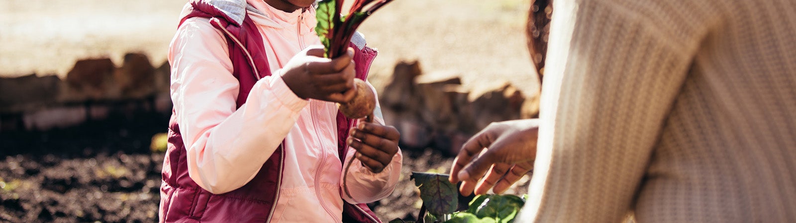 Little girl helping her mother in the garden
