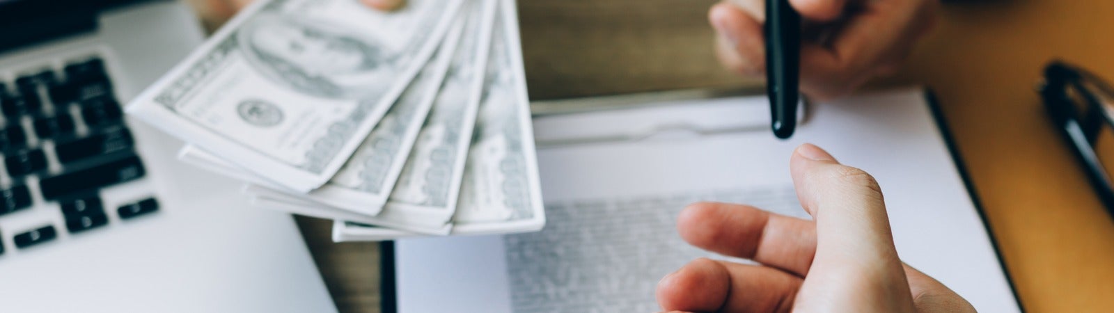 People signing paperwork and exchanging cash