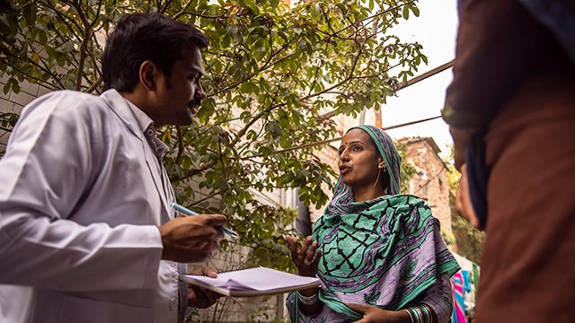 Man talking to woman and taking notes in South Asia