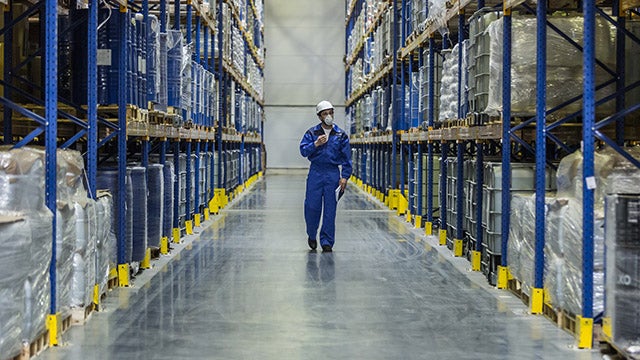 Worker in hardhat walks through factory