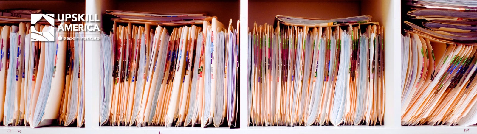 Close up image of files in shelves with the UpSkill America logo on the top left corner.
